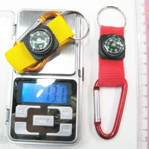 Detailed view of a mini compass carabiner keychain on a digital scale showing 13.1g weight