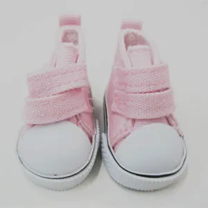 Nahaufnahme von 5 cm großen rosa Puppensneakern mit weißer Gummikappe und Klettverschluss