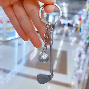 Λεπτομερής μακροεντολή ενός μίνι ασημένιου μπρελόκ για μπαστούνι και μπάλα γκολφ.