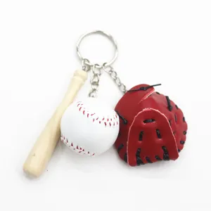 Detail view of mini baseball keychain set featuring a wooden bat, red glove, and leather ball