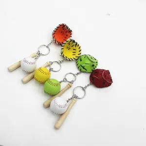 Macro detail view of colorful baseball glove and mini wooden bat sports keychain charms.