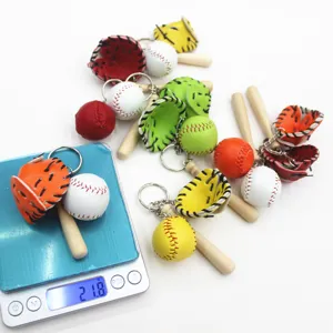 Close-up showing the 21.8g weight measurement of a baseball keychain set on a digital scale.