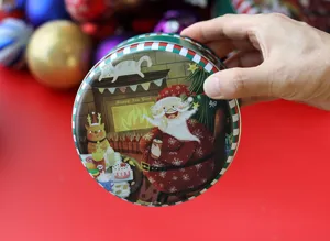 Boîte ronde en métal pour biscuits de Noël avec charmante illustration, emballage cadeau festif.