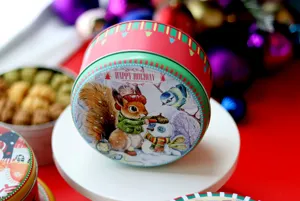 Boîte ronde en fer-blanc de Noël pour biscuits avec charmant design de bonhomme de neige.