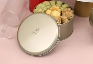 Caja de hojalata redonda para galletas con tapa, ideal para almacenamiento de repostería.