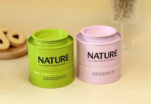Barattolo per tè cilindrico impilabile e contenitore in latta in delicate tonalità verde e rosa.