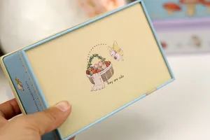 Gros plan détaillé de la boîte cadeau carrée, avec une illustration mignonne et épurée.