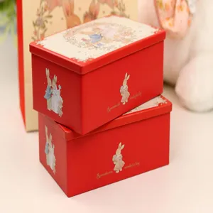 Vue détaillée des boîtes à bonbons de mariage rouges avec de jolies illustrations de lapin