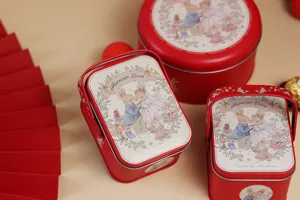 Detail view of red tin wedding souvenir gift box featuring cute rabbit wedding illustration.