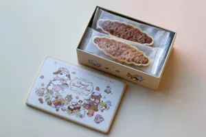 Coffret cadeau en boîte métallique carrée avec jolies illustrations d'animaux et en-cas emballés.