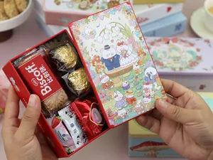 Detail view of the red wedding favor tin box, showing neatly arranged cookies and chocolates inside.