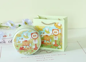 Scatola regalo rotonda in latta goffrata e sacchetto con illustrazioni di orsi e conigli