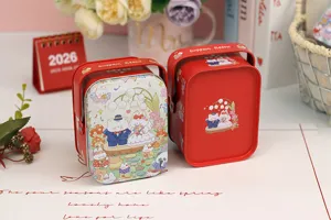 Gros plan de la boîte en fer blanc de mariage rouge avec couple d'ours et poignée portable.