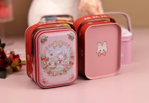 Gros plan détaillé de la boîte-cadeau rose en fer-blanc avec joli motif lapin et fraise.