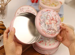 Boîte en fer blanc rose ronde avec illustration mignonne, parfaite pour biscuits et cadeaux.