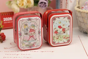 Boîte en fer blanc pour bonbons de mariage rouge avec de jolies illustrations de mariés.