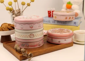 Jolie boîte ronde rose en métal pour biscuits et cadeaux, emballage charmant au design mignon.