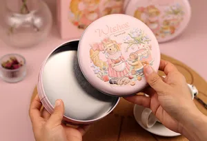 Vue rapprochée détaillée de l'intérieur de la boîte en fer blanc rose et de son couvercle.