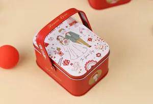 Vue détaillée de la boîte à bonbons de mariage rouge avec des motifs de mariés mignons.