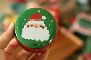 Gros plan sur les details de la boite en fer-blanc de Noel avec motif de pere Noel.