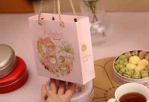 Sac cadeau en papier rose avec illustration d'animaux mignons et poignées dorées biscuits