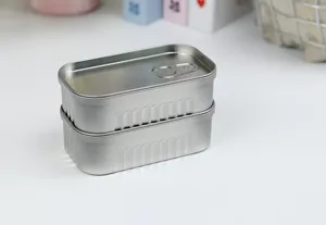 Gros plan détaillé de boîtes de sardines en fer-blanc argenté sur un bureau blanc propre.