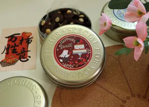 Vue détaillée d'une boîte en fer-blanc ronde avec du texte de bénédiction et des biscuits.