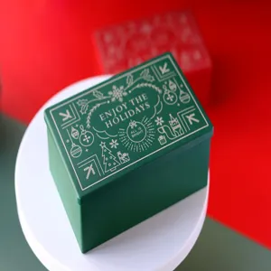 Vue détaillée de la boîte en fer-blanc de Noël rectangulaire verte avec motif de fête.