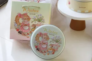 Dettaglio della scatola in latta rotonda con coniglio e sacchetto regalo coordinato