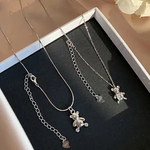 Λεπτομέρεια από ασημί κολιέ με μενταγιόν αρκουδάκι και λαμπερά κρύσταλλα σε κουτί
