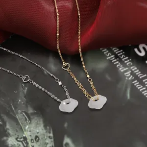 Dettaglio di eleganti ciondoli a forma di nuvola in calcedonio bianco e oro