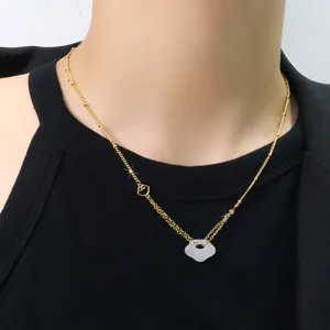 Primo piano di una collana placcata in oro con ciondolo serratura Ping'an in calcedonio