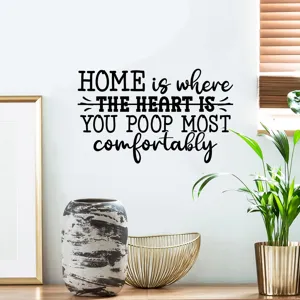 Detail of humorous 'Home is where you poop most comfortably' wall decal in home interior