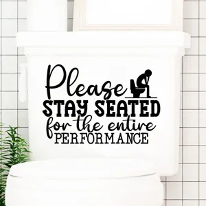 Funny 'Please Stay Seated' black vinyl decal applied on a white porcelain toilet tank