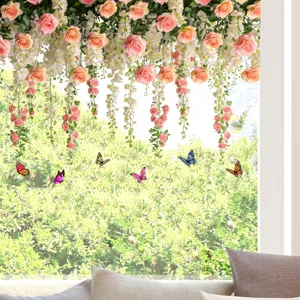 Close-up view of vibrant butterfly and hanging rose stickers on a bright window pane