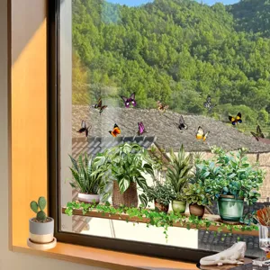 Detailed view of green plant and butterfly static cling window stickers on glass