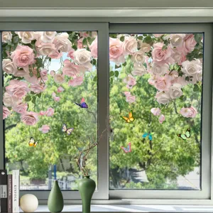 Close-up of pink rose and colorful butterfly window stickers on a glass window pane