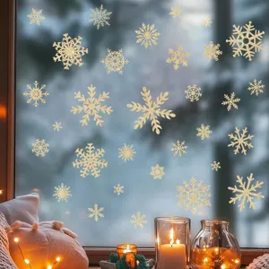 Dettaglio di adesivi glitterati a forma di fiocco di neve dorati su un vetro piano