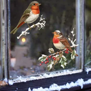 Detail of realistic robin window stickers on snow-covered holly branches for winter decor