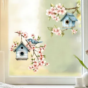 Watercolor style birdhouse and blossom branch window stickers shown on a glass window.