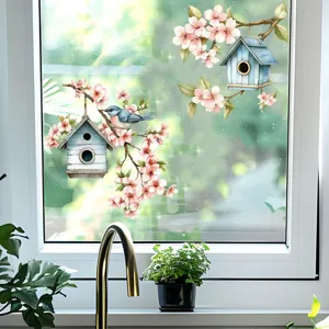Detail view of floral birdhouse window stickers on a bright kitchen window glass