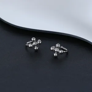 Macro view of minimalist silver cross bead ear cuff design with metallic finish