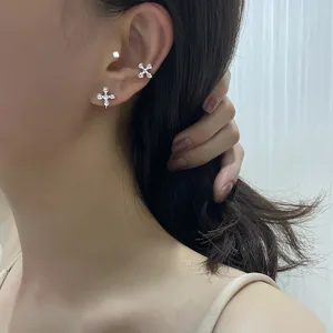 Detailed view of minimalist silver cross beaded ear cuffs elegantly worn on a female ear