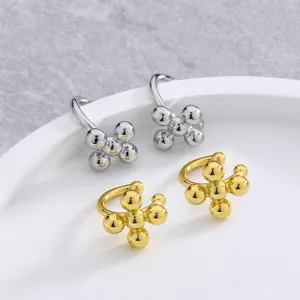 Detail view of gold and silver minimalist cross ball ear cuffs for non-pierced ears