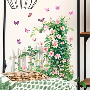 Detail van muursticker met roze bloemen, een wit hek en paarse vlinders op een witte muur.