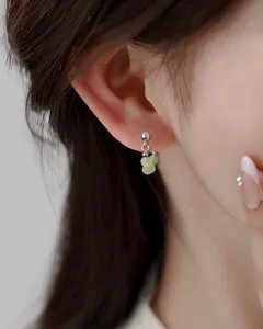 Close-up detail of elegant light green jade bead earrings worn by a model in New Chinese style