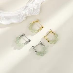 Detail view of elegant light green jade bead earrings in gold and silver finishes