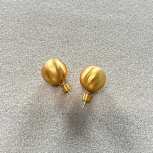Vista detallada de pendientes de botón de bola dorados mate con textura cepillada