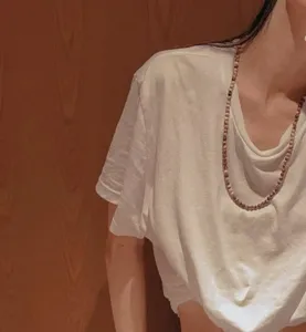 Gedetailleerd overzicht van een lange ketting van natuurlijke zebrameren op wit t-shirt