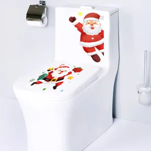 Detail showing festive Santa Claus stickers applied on a white ceramic toilet for bathroom.